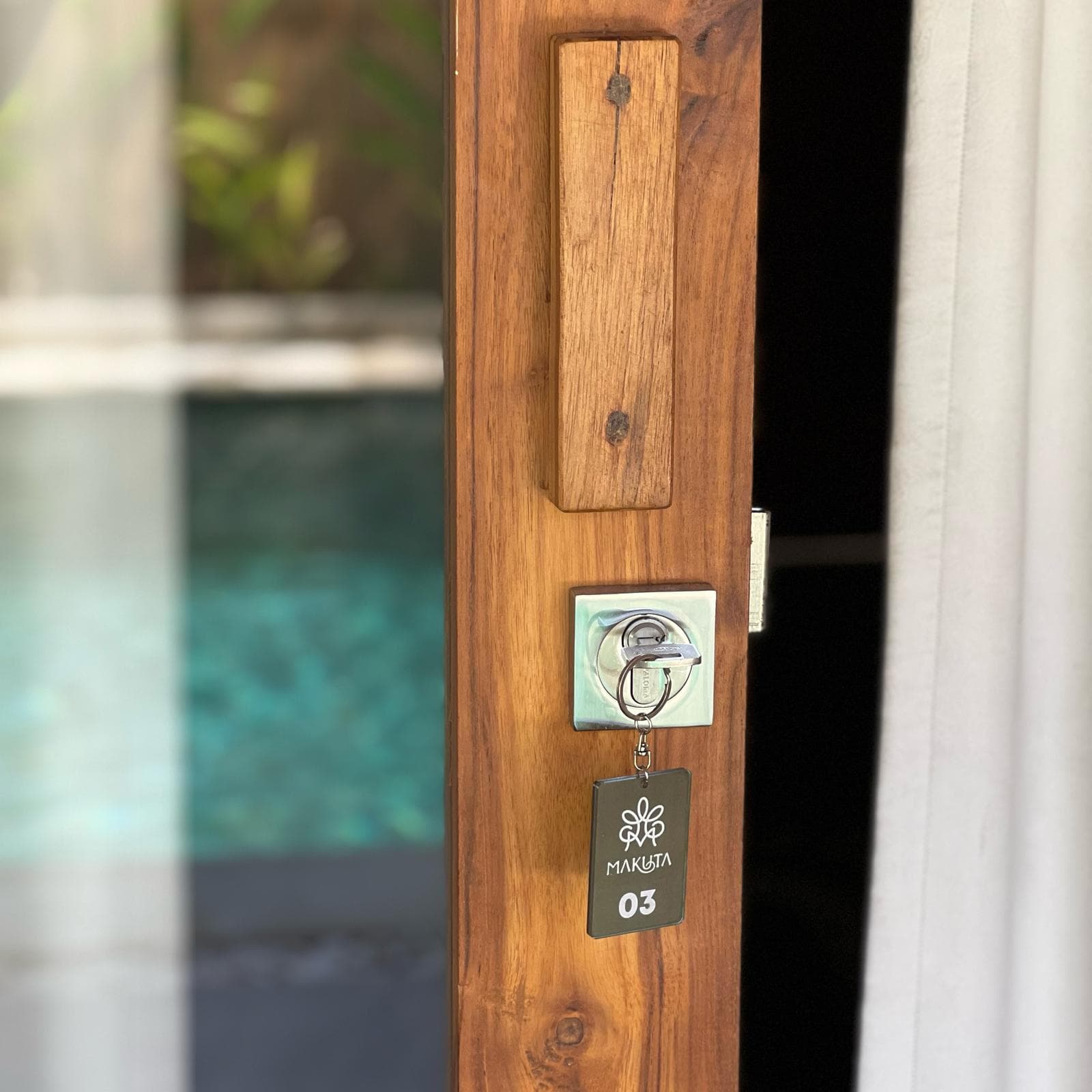 Makuta room key on a teak door